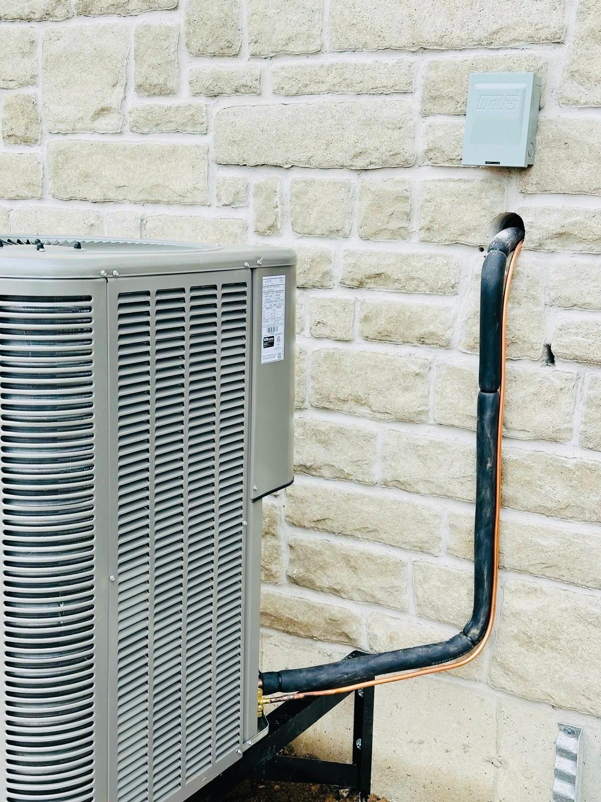 Professional air conditioner installation on stone wall exterior in Brampton, featuring clean refrigerant line insulation.