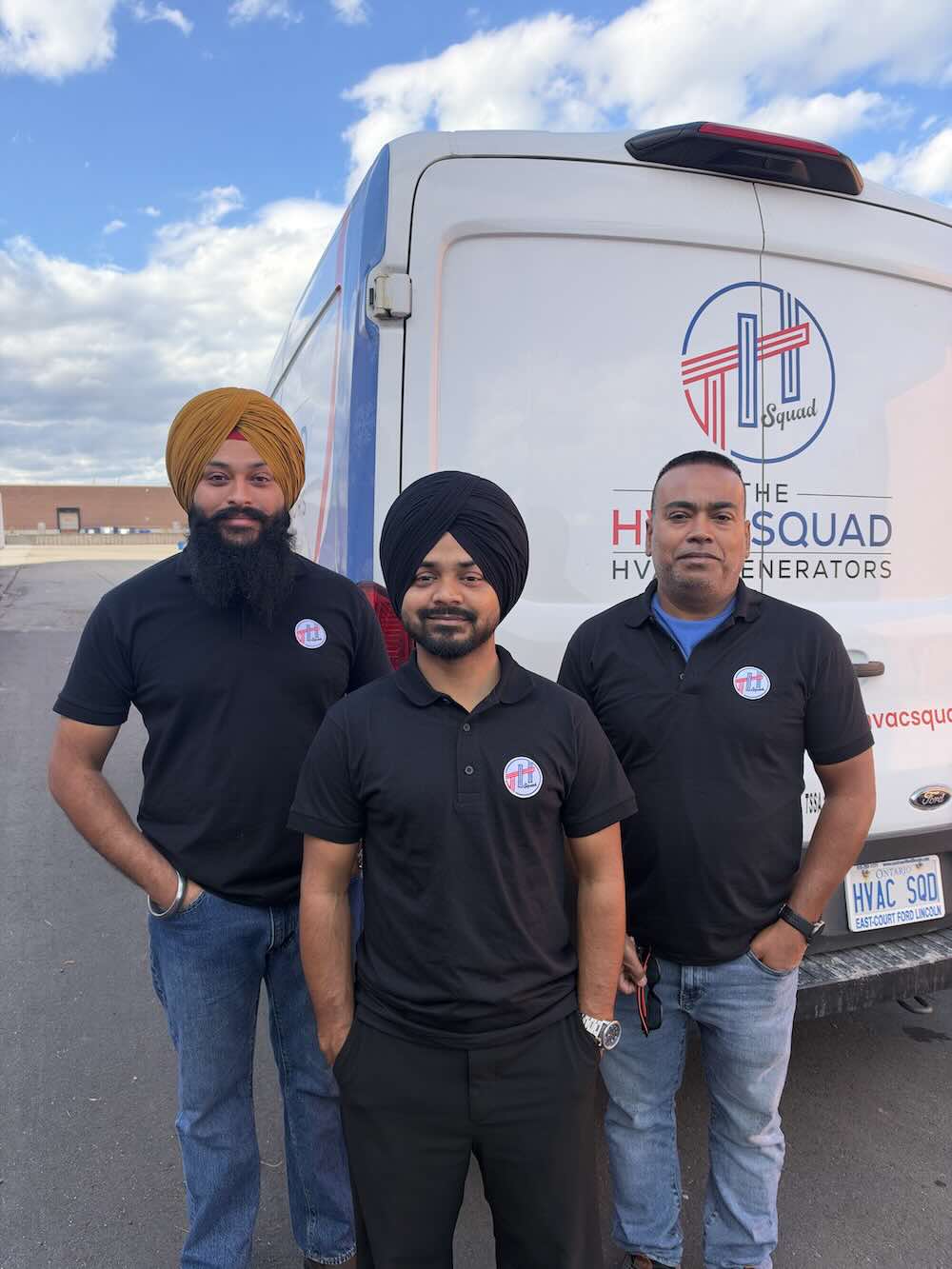 Three The HVAC Squad technicians standing beside a branded company van